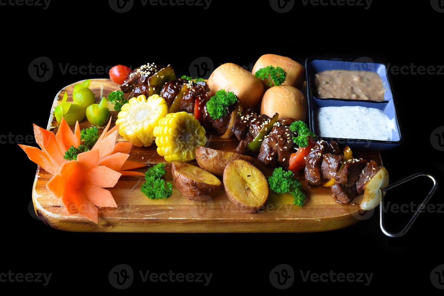 Beef skewers with pepper and corn served with vietnamese buns on black background top view photo