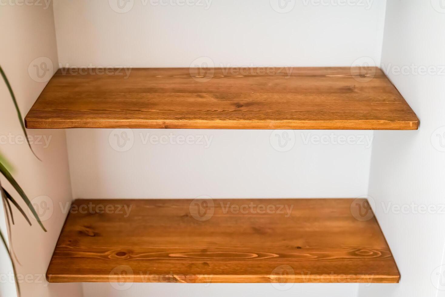 2 empty wooden shelves on the white wall photo