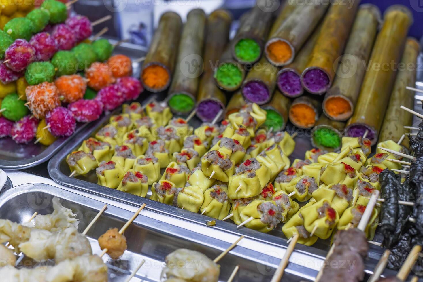 Skewers with meat and sticky rice in bamboo in vietnamese night market photo