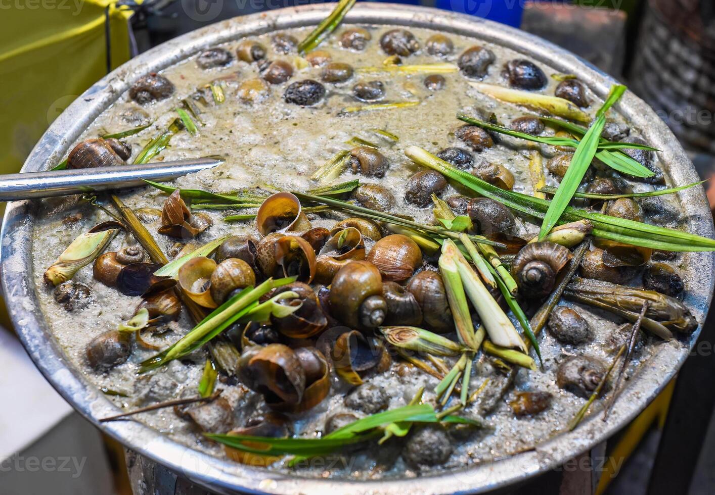 stewed snails with vegetables and lemongrass in bamboo in vietnamese market photo