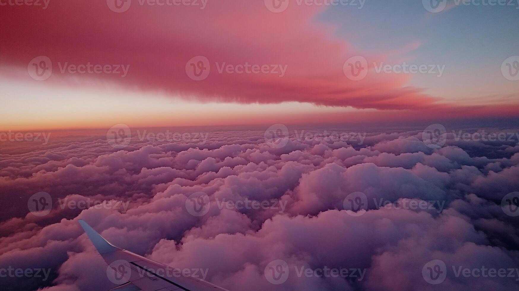 Aerial view of sunset clouds from airplane window. Vast expanse of fluffy cumulus clouds colored by the setting sun photo