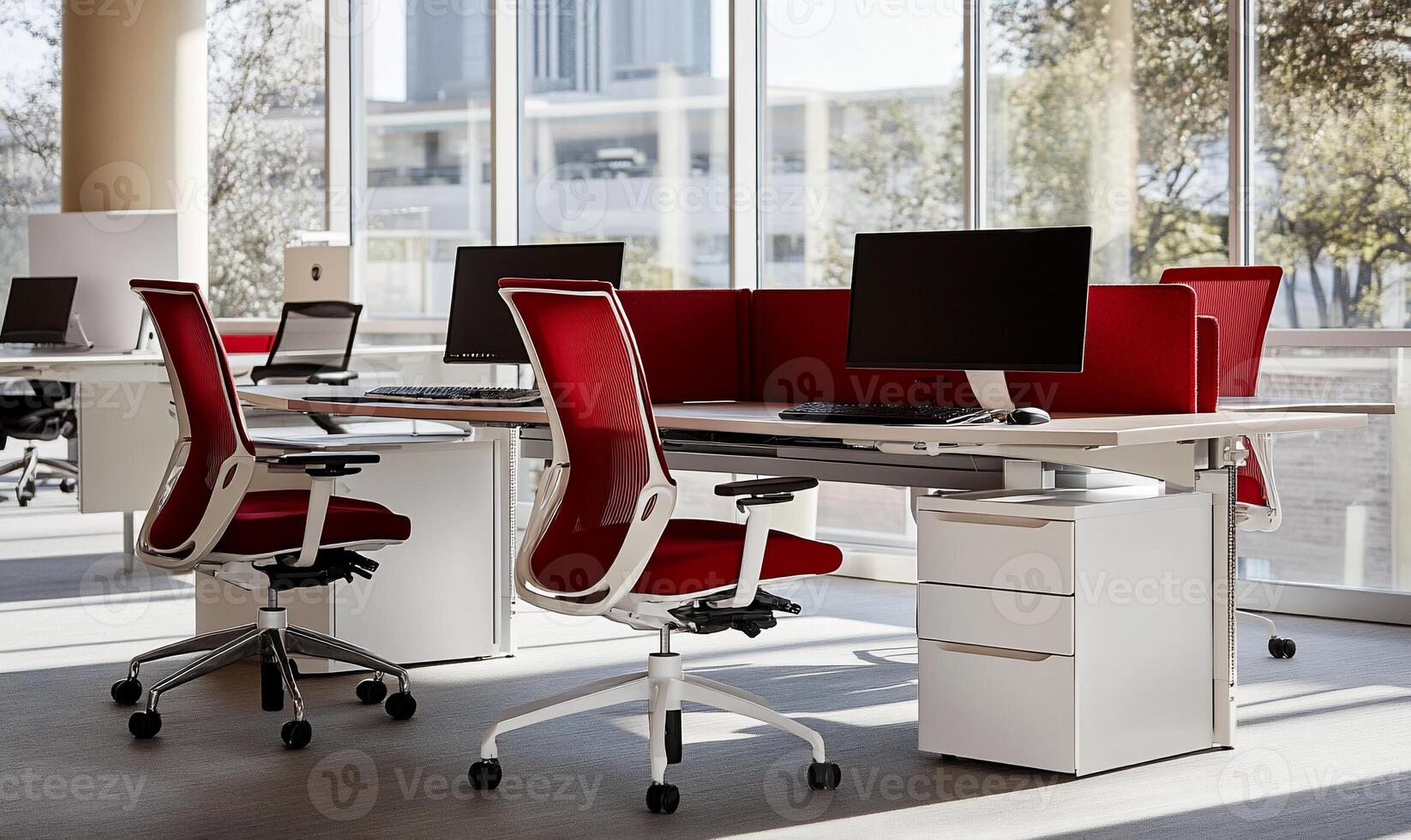 Modern office workspace with red accents. Open plan layout featuring white desks and chairs with red mesh backs. Natural light streams through large windows photo