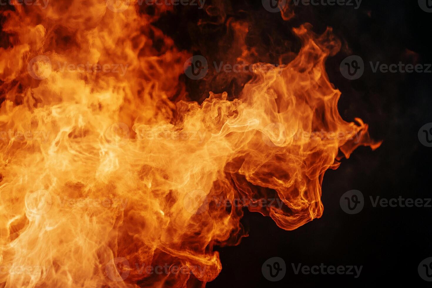 Fiery flames erupting against a dark background. Detailed close-up view of intense fire patterns photo