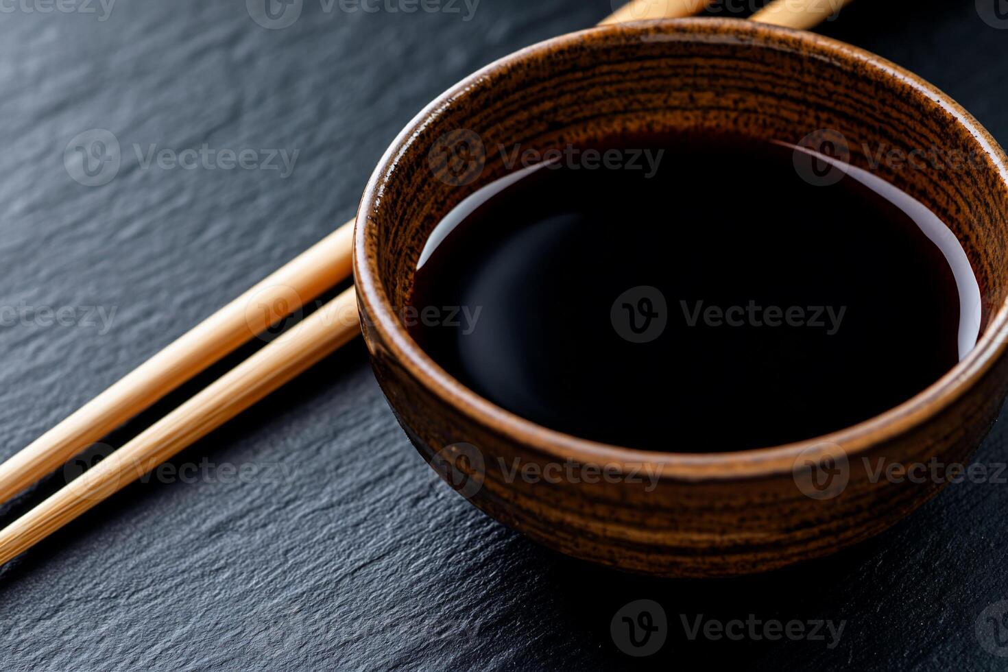 A bowl of black soy sauce and chopsticks photo