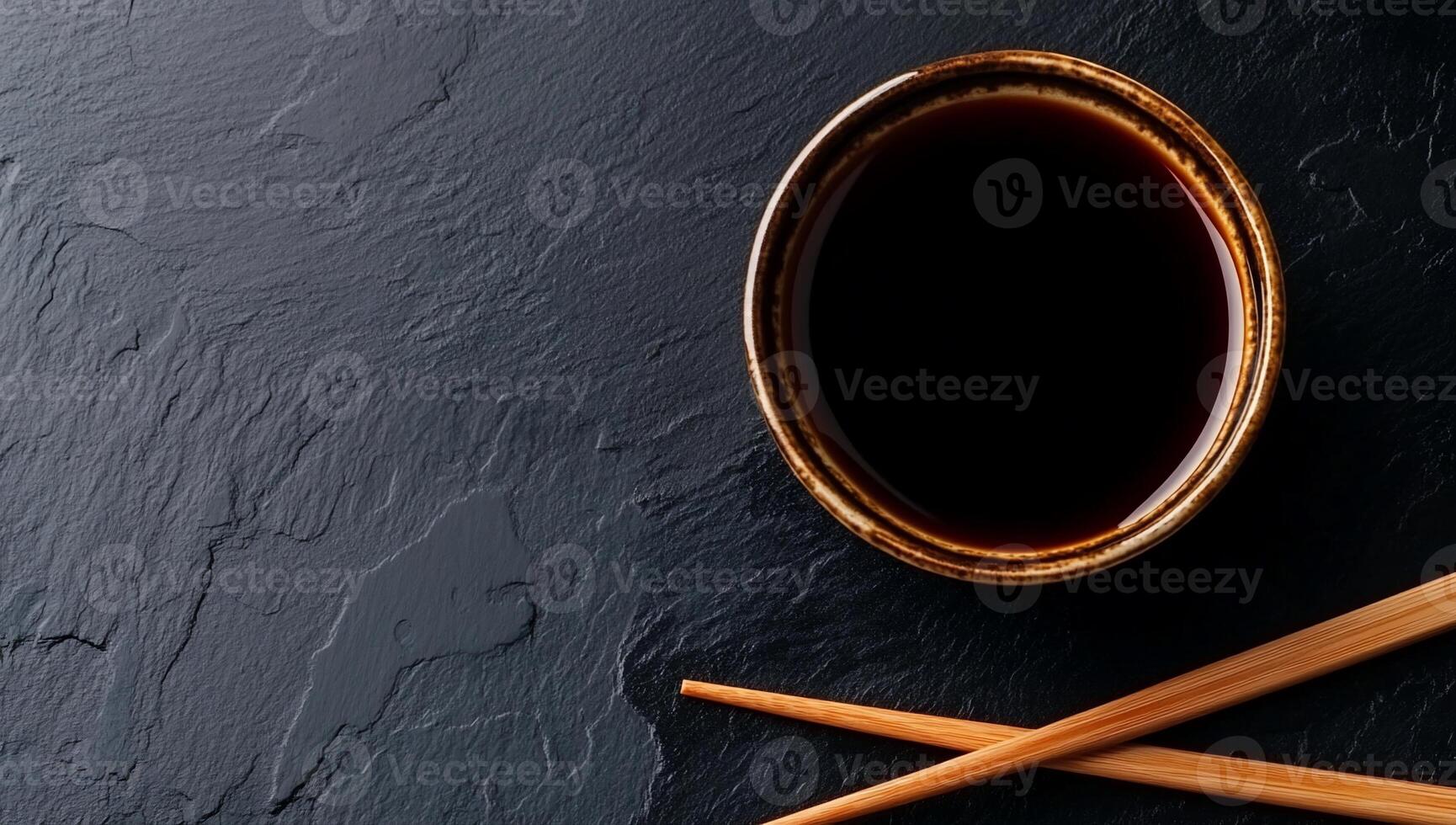 Dark soy sauce in a bowl on dark slate photo