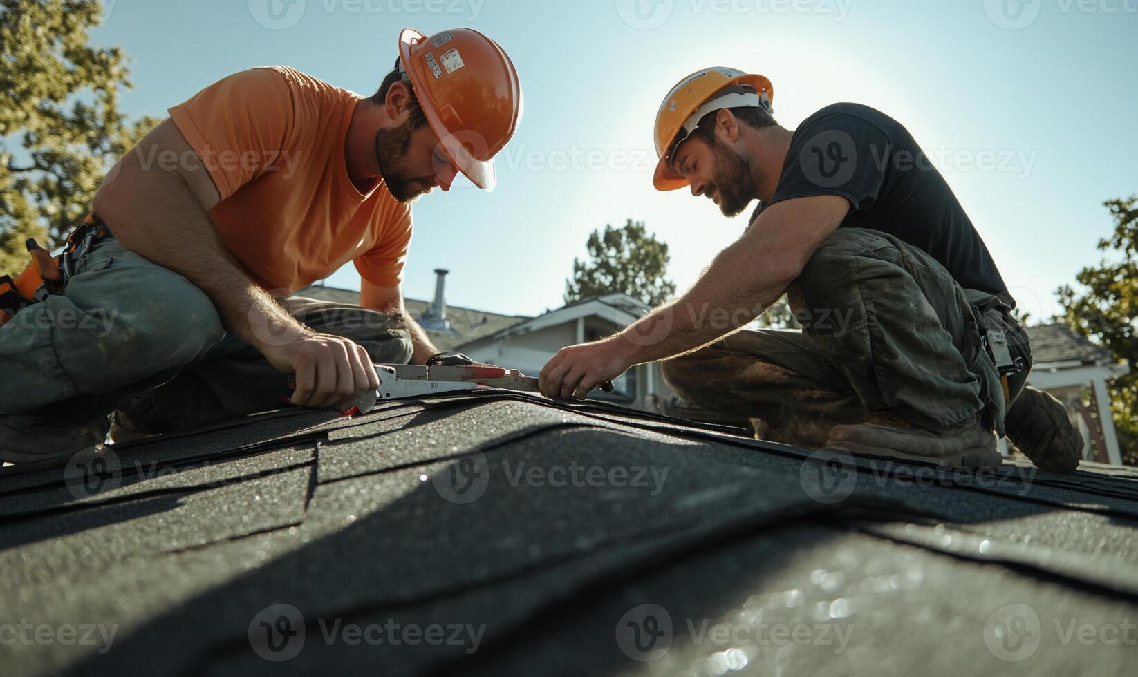 Two construction workers installing roofing shingles photo