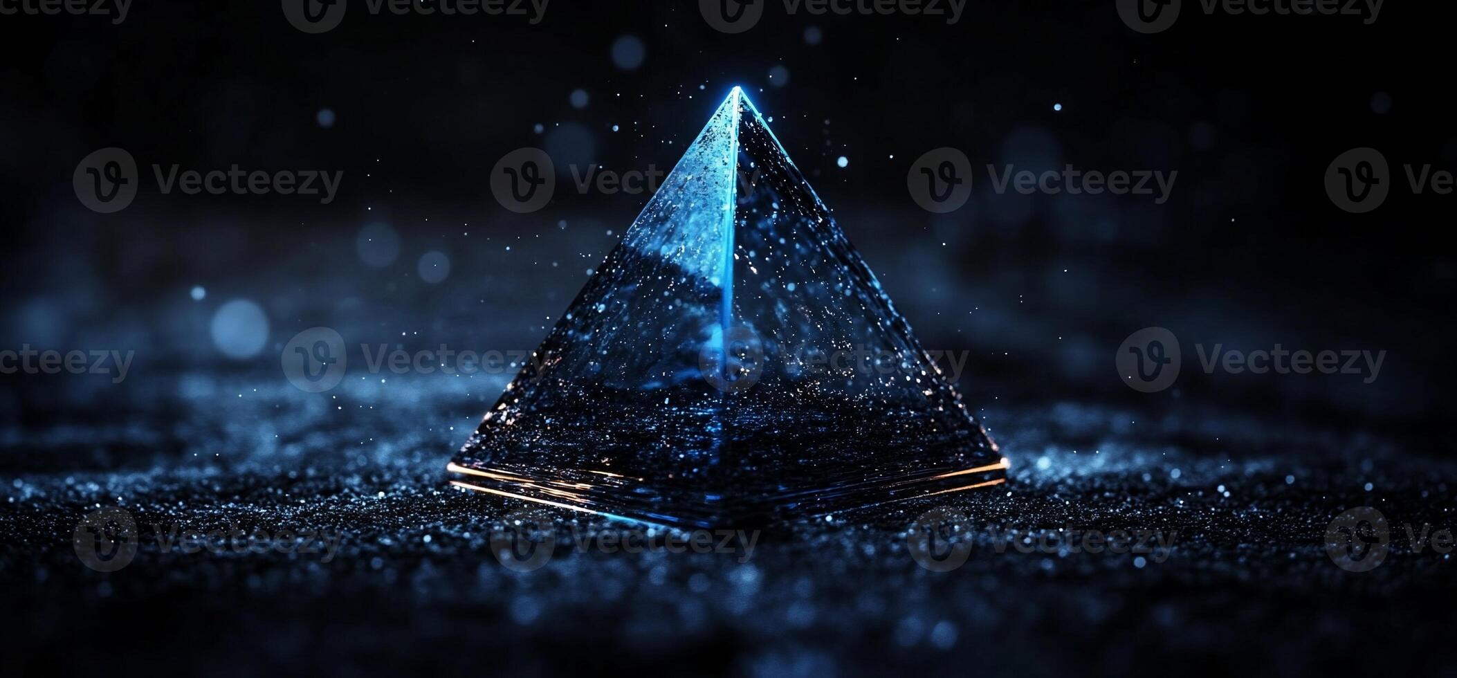 Glowing blue pyramid on dark surface photo