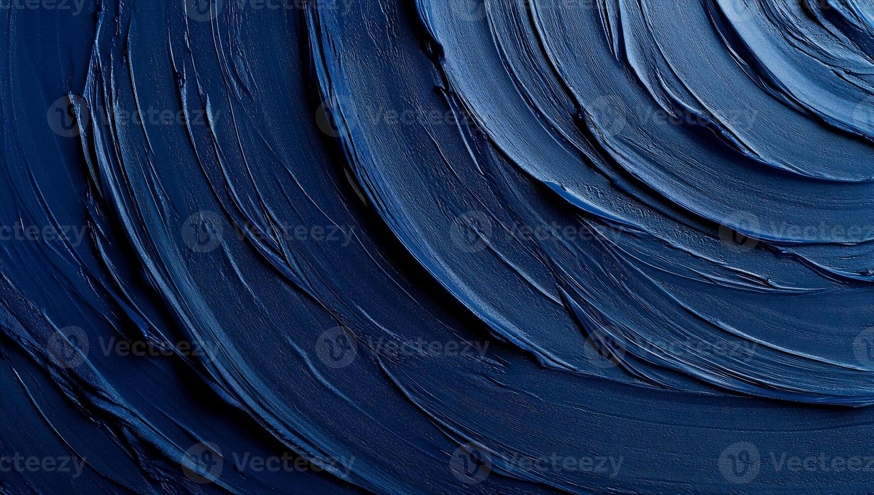 Deep blue swirls of thick paint create a mesmerizing circular texture photo