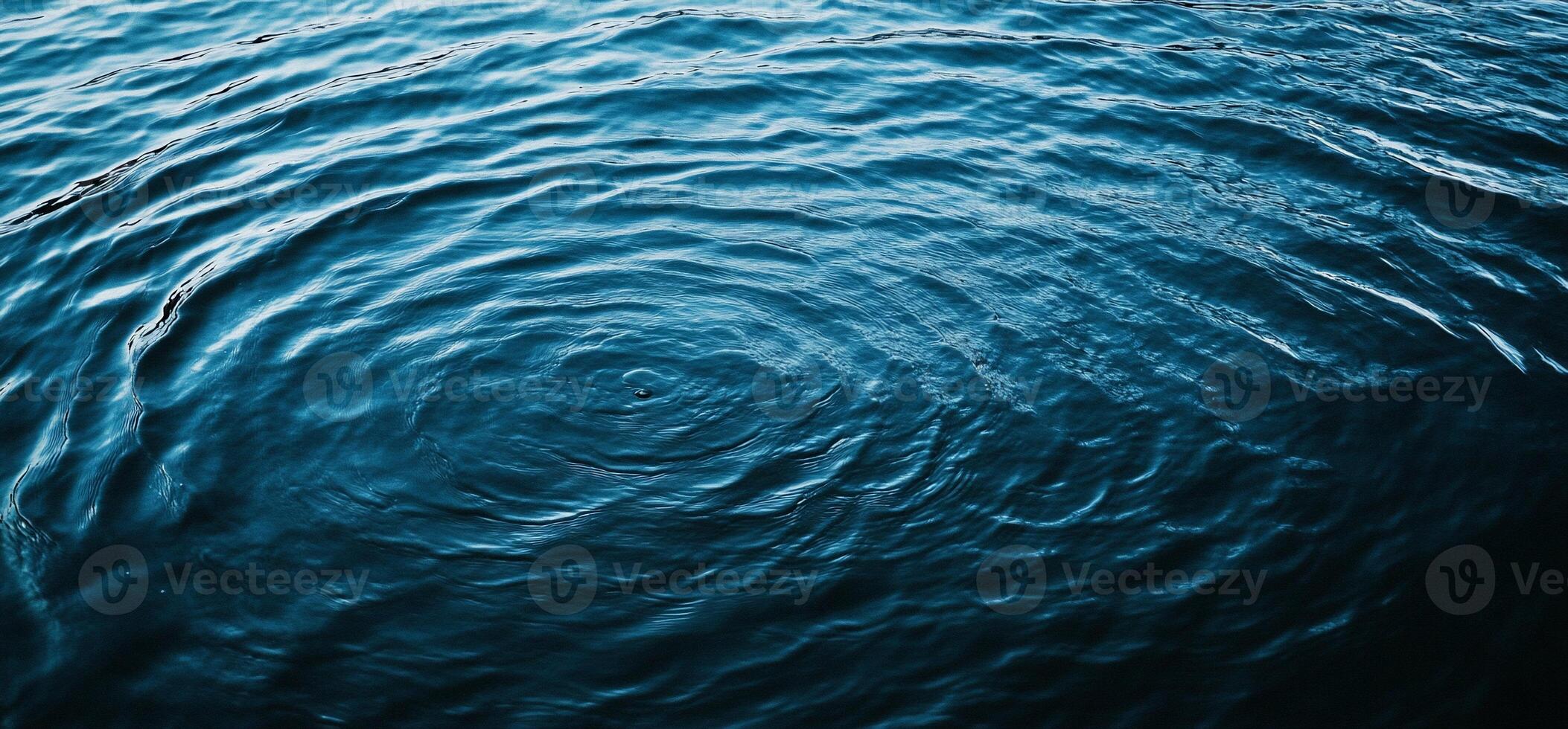 Deep blue water ripples, concentric circles emanating from a central point photo