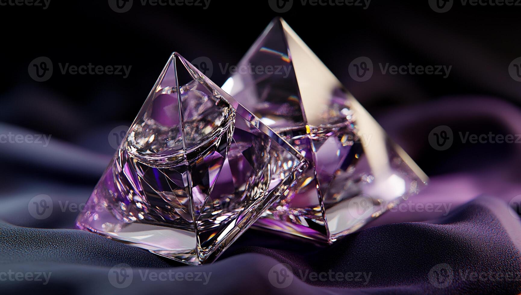 Two exquisite crystal pyramids, violet-hued, rest on dark fabric photo