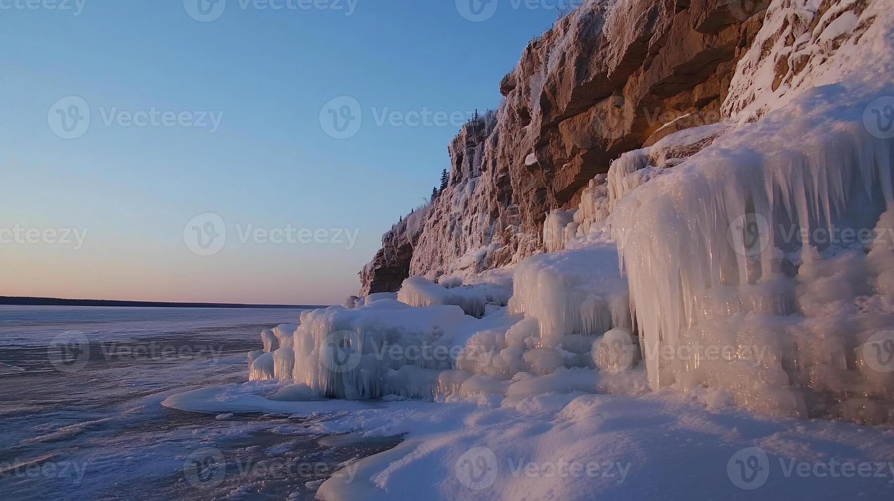 Frozen cliff face at sunset, icy formations cascading down photo
