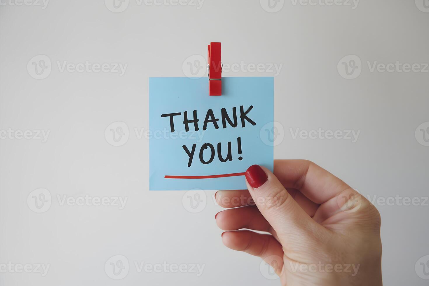 Hand holds THANK YOU note secured with red clothespin on white backdrop photo