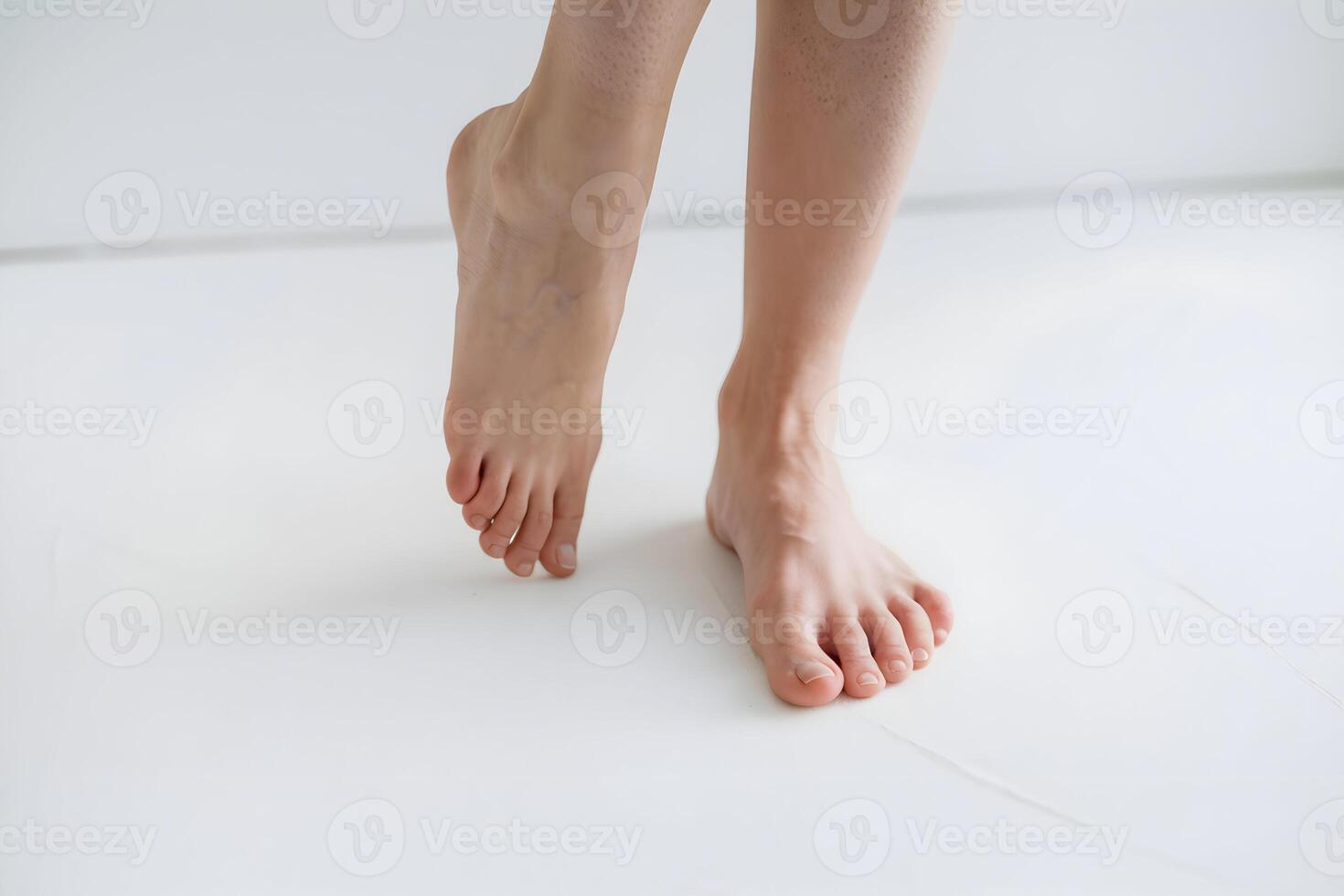 Bare feet on white surface, relaxed stance, plain white background photo