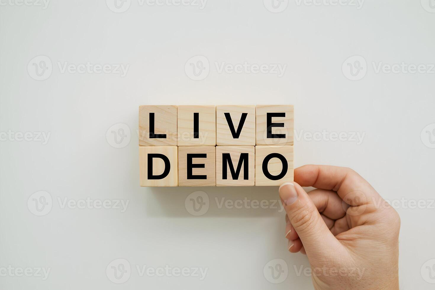 Hand holding wooden blocks spelling LIVE DEMO against a white background photo
