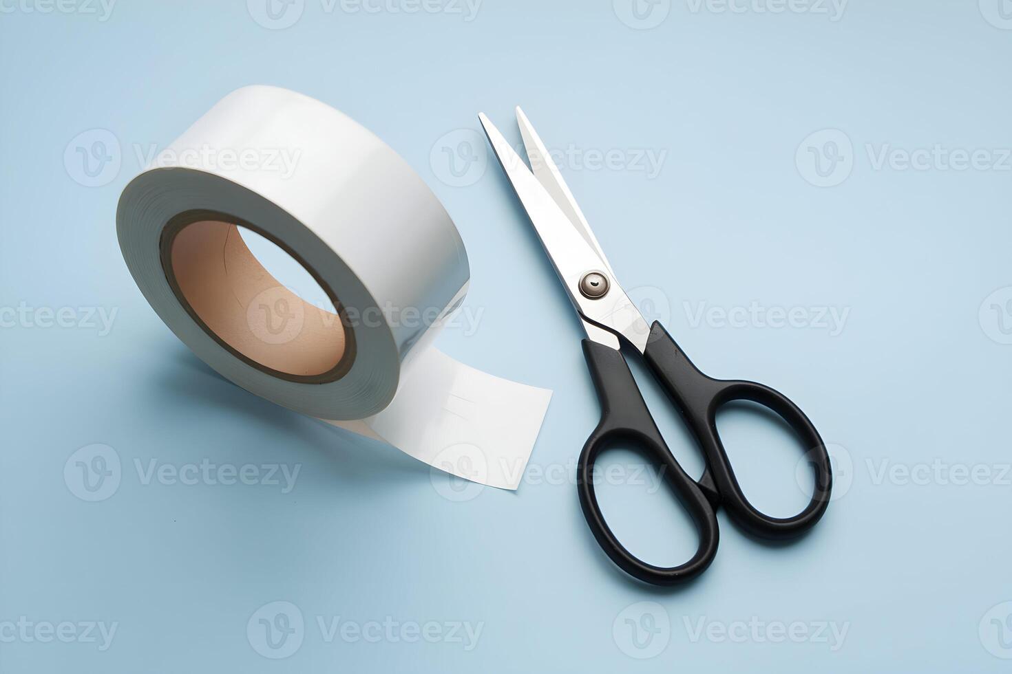 White tape roll and black scissors on a light blue background photo