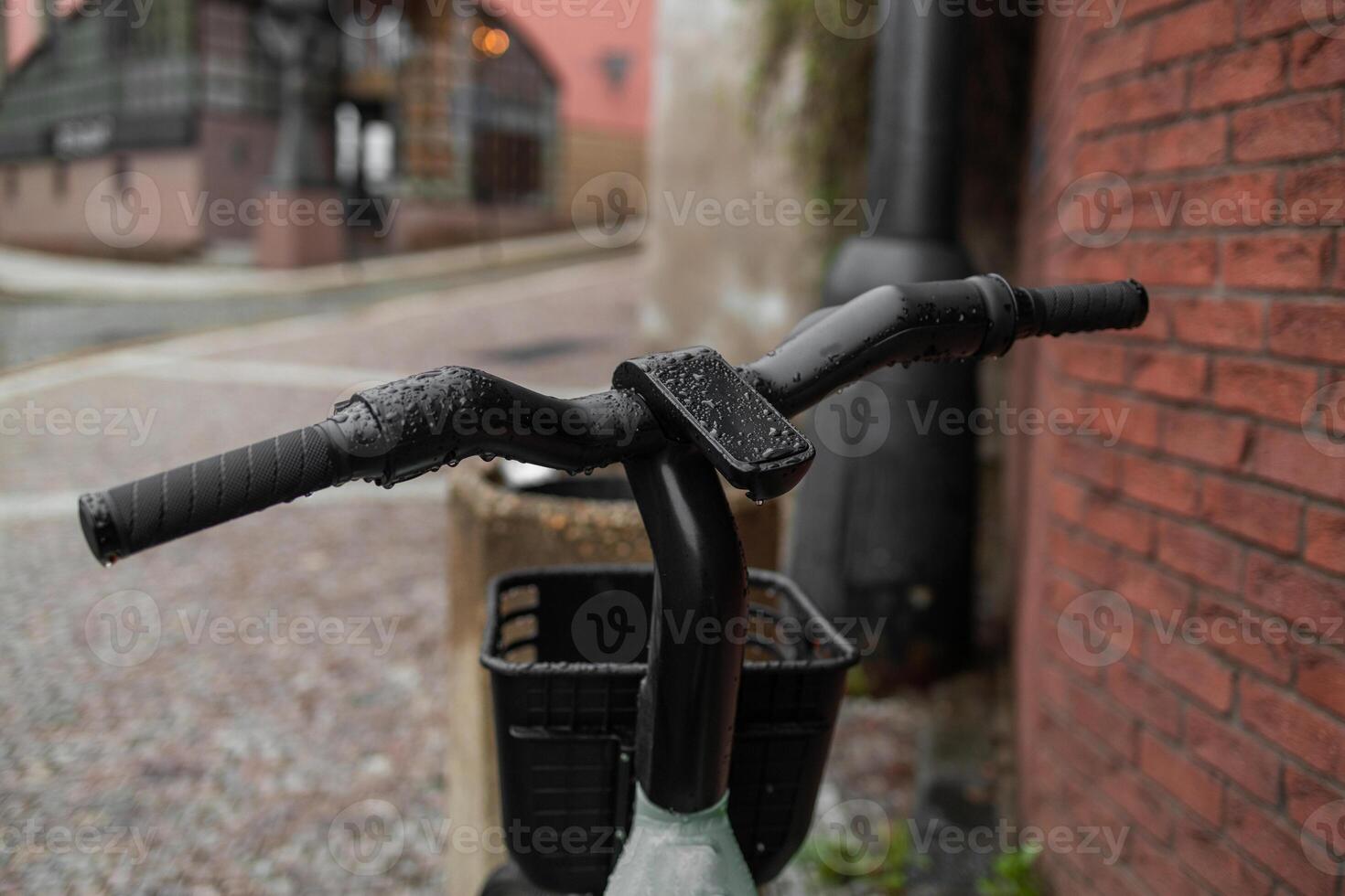 Close-up of a bicycle handlebar with a bell and sticker, blurred bikes in the background photo