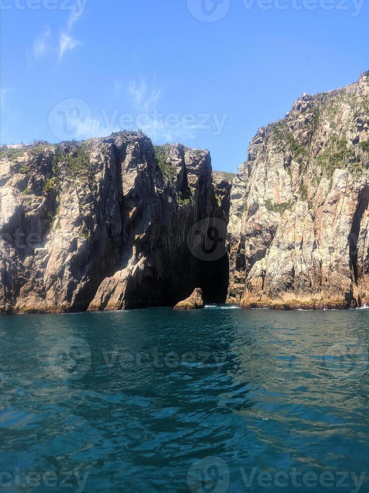 rock sea cave blue sky photo