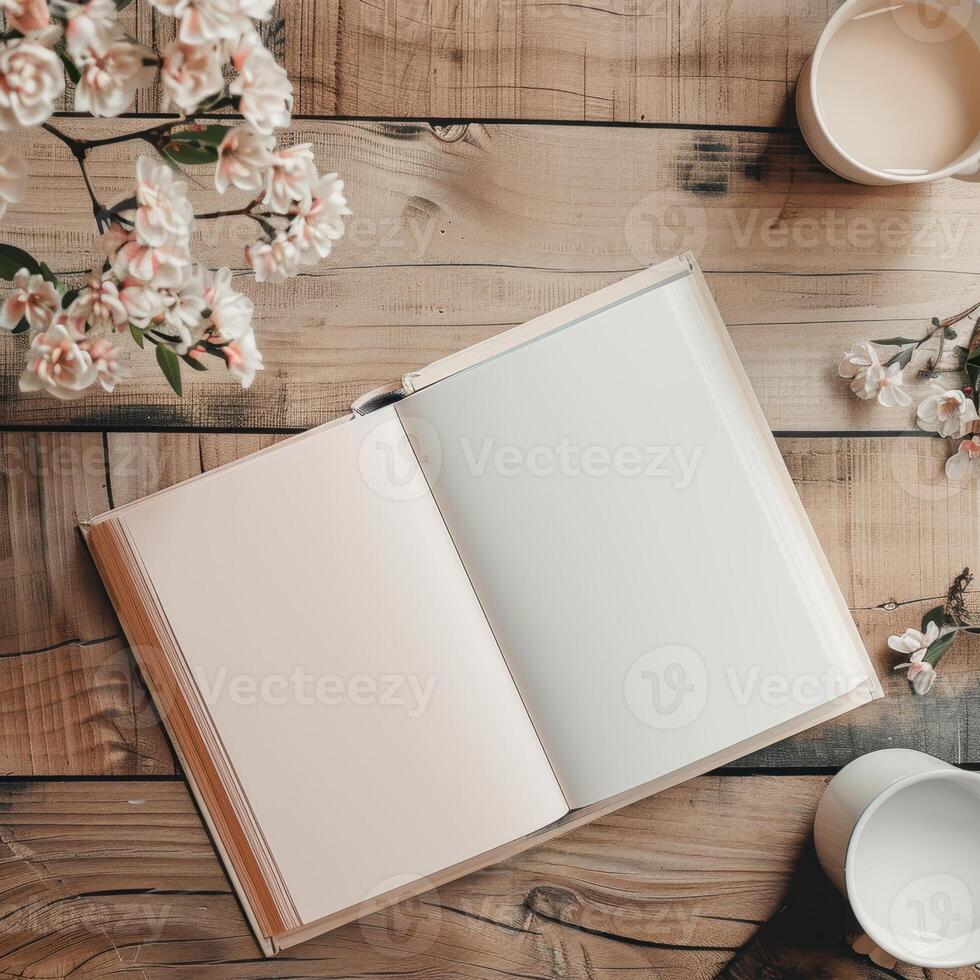 An open book and coffee cup on a wooden table with flowers photo