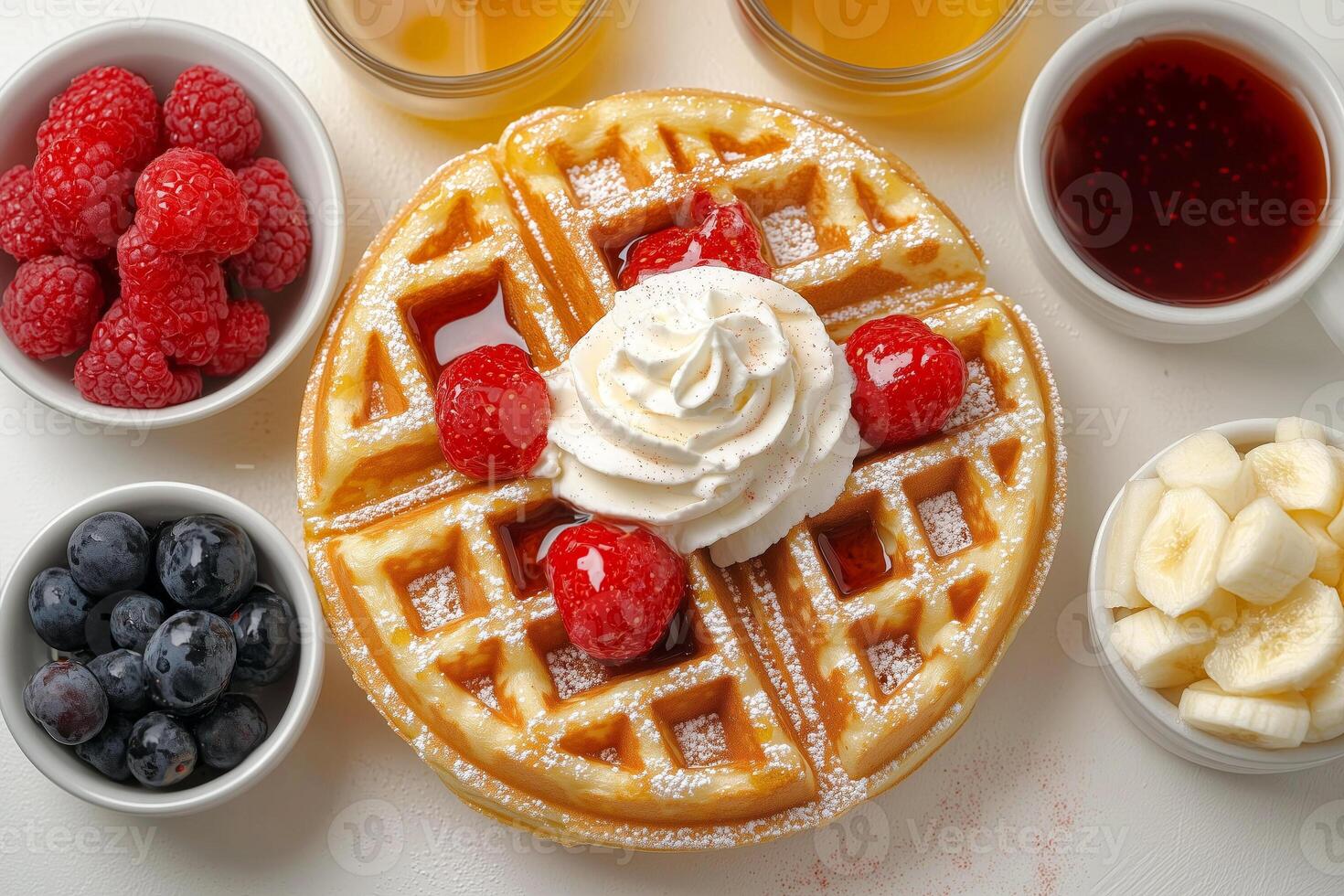 Breakfast waffles with fresh fruit, whipped cream, and syrup on a table photo