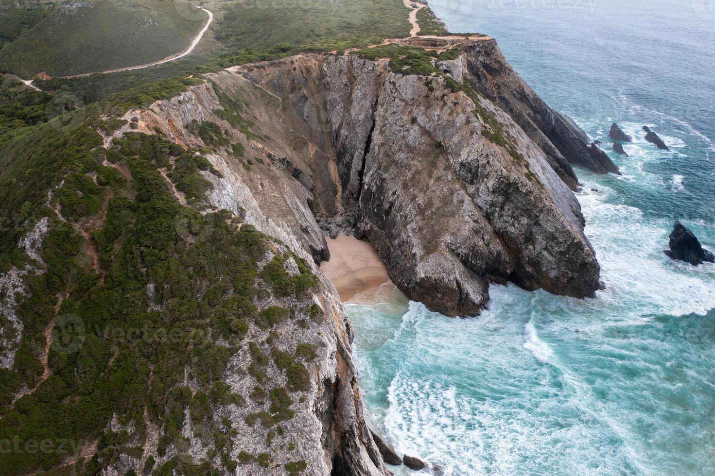 Drone view of huge rocky cliffs on seaside at beach during daytime photo