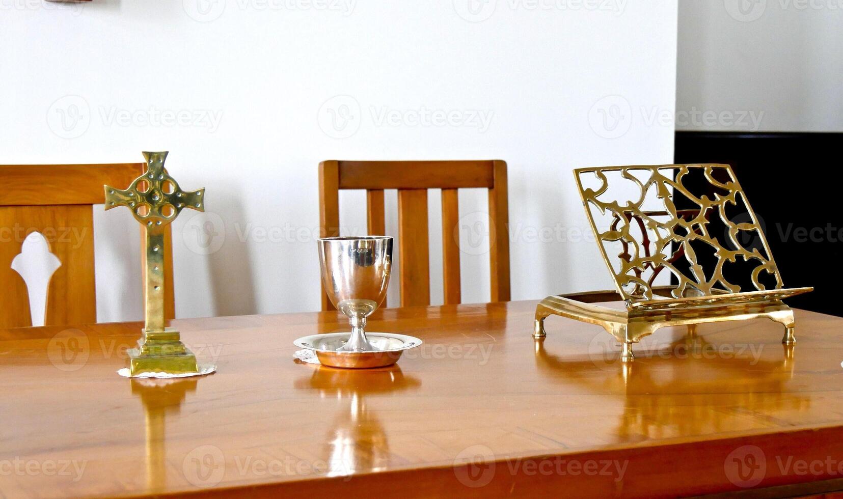 a wooden table with a cross and a vase on it photo