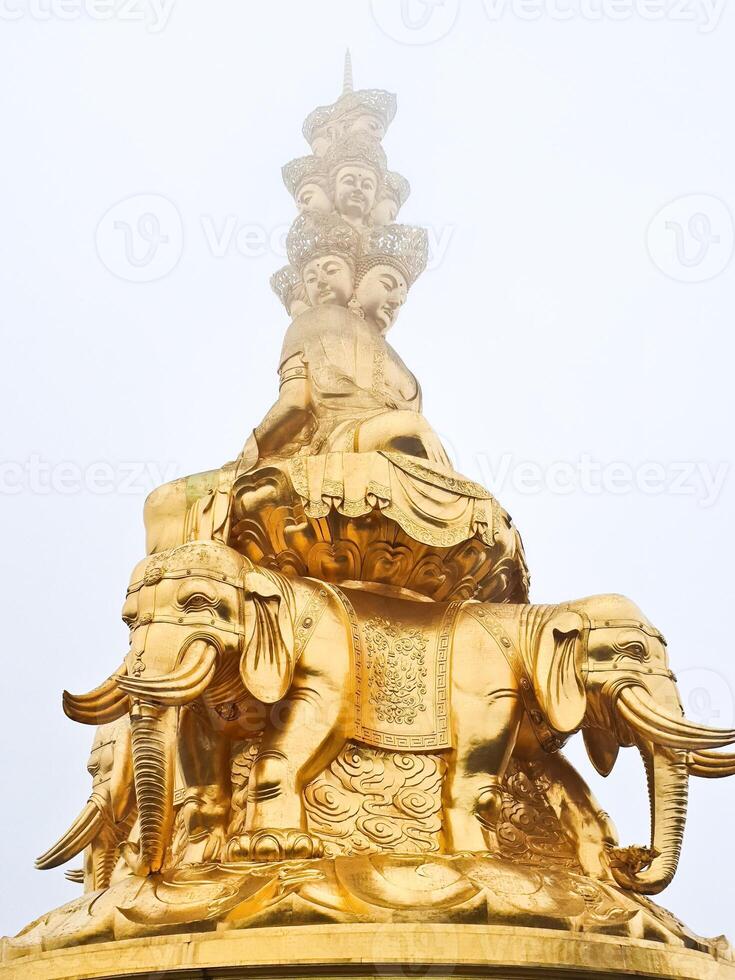 a golden statue of a buddha sitting on top of elephants photo