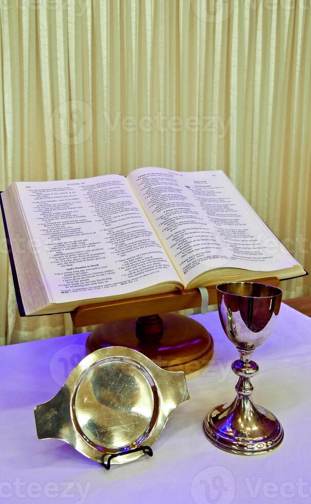 a silver chalice and a silver book on a table photo