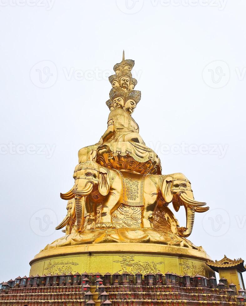 a golden statue of buddha on an elephant on top of a building photo