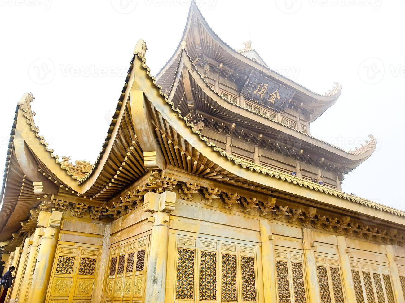 a golden buddhist temple pagoda in the foggy weather photo