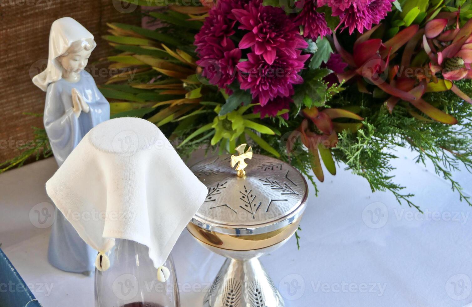 a vase with flowers and a statue of the virgin mary photo