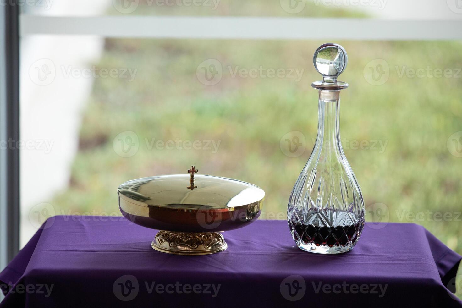 a wine decanter and a gold bowl on a purple table photo