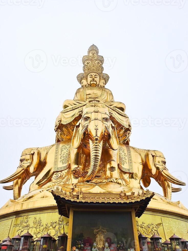 a golden statue of an elephant with buddha sitting on it photo