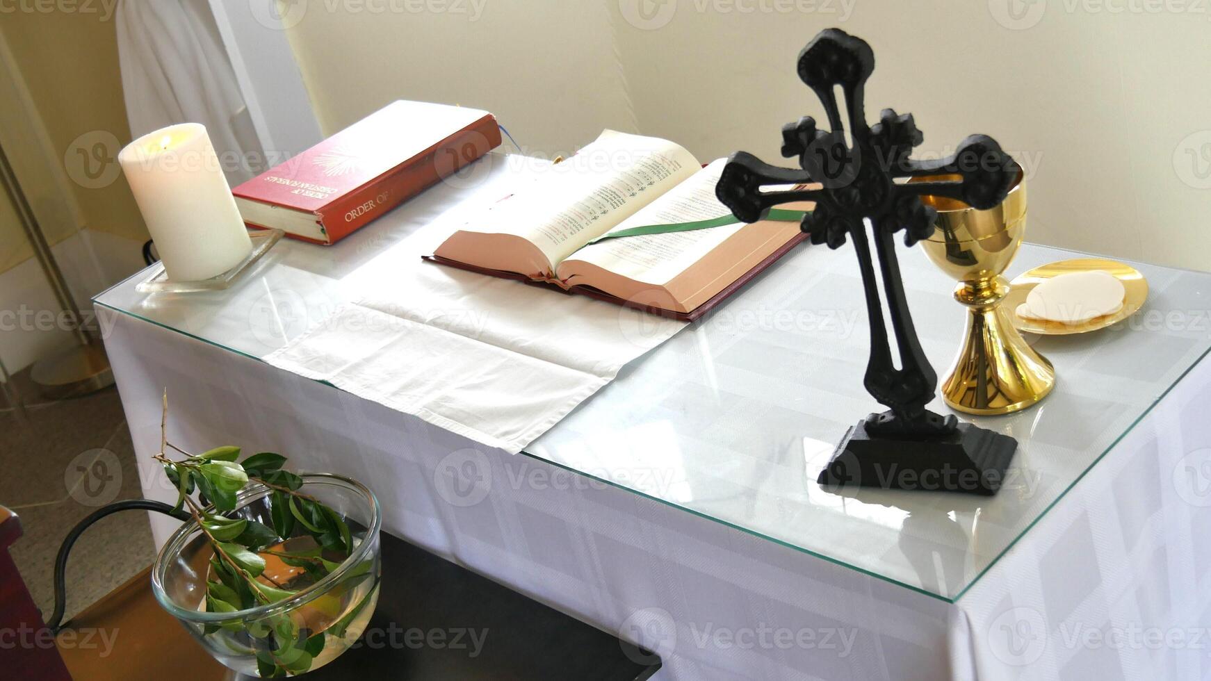 a cross sits on a table with a book and candle photo