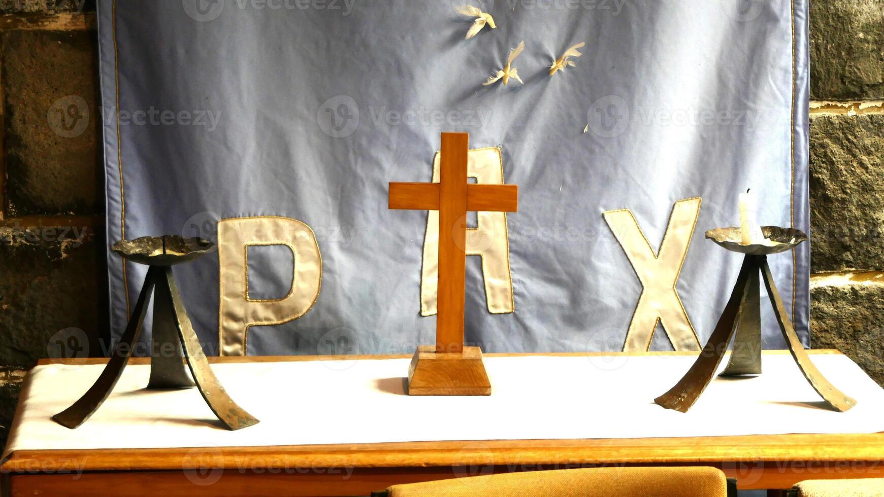 a cross and two candles on a table in front of a banner photo