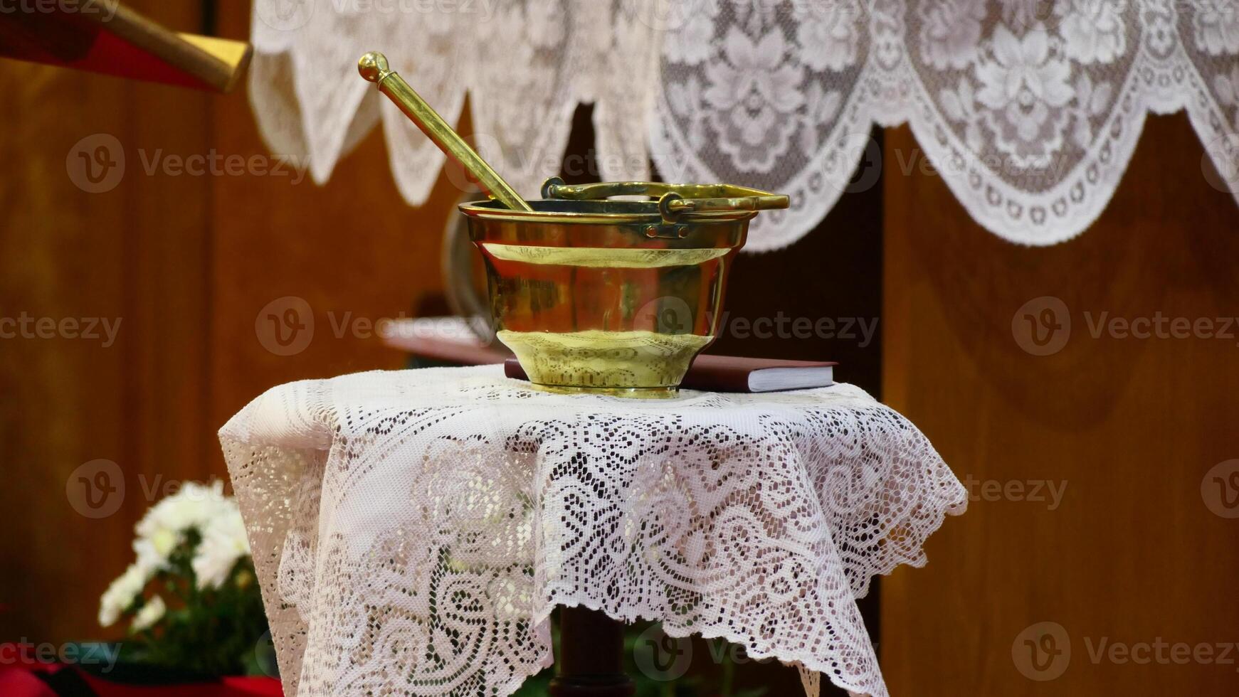 a gold cup on a table with a lace table cloth photo