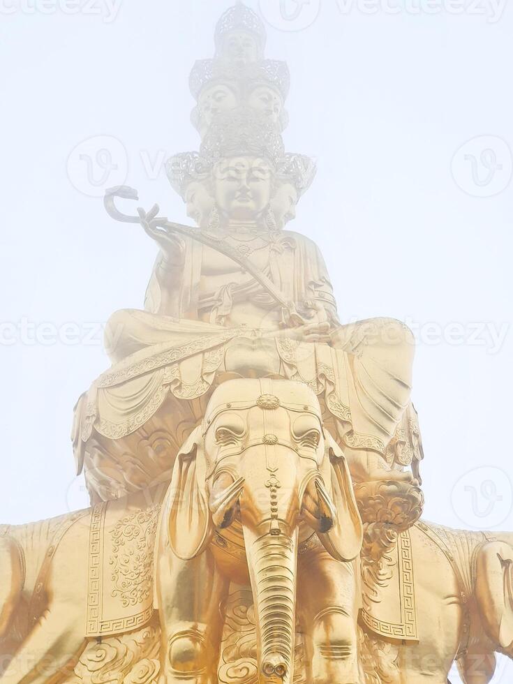 a statue of buddha sitting on top of an elephant photo