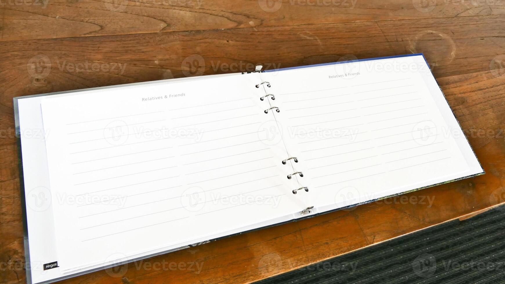 a notebook with a blank page on a wooden table photo