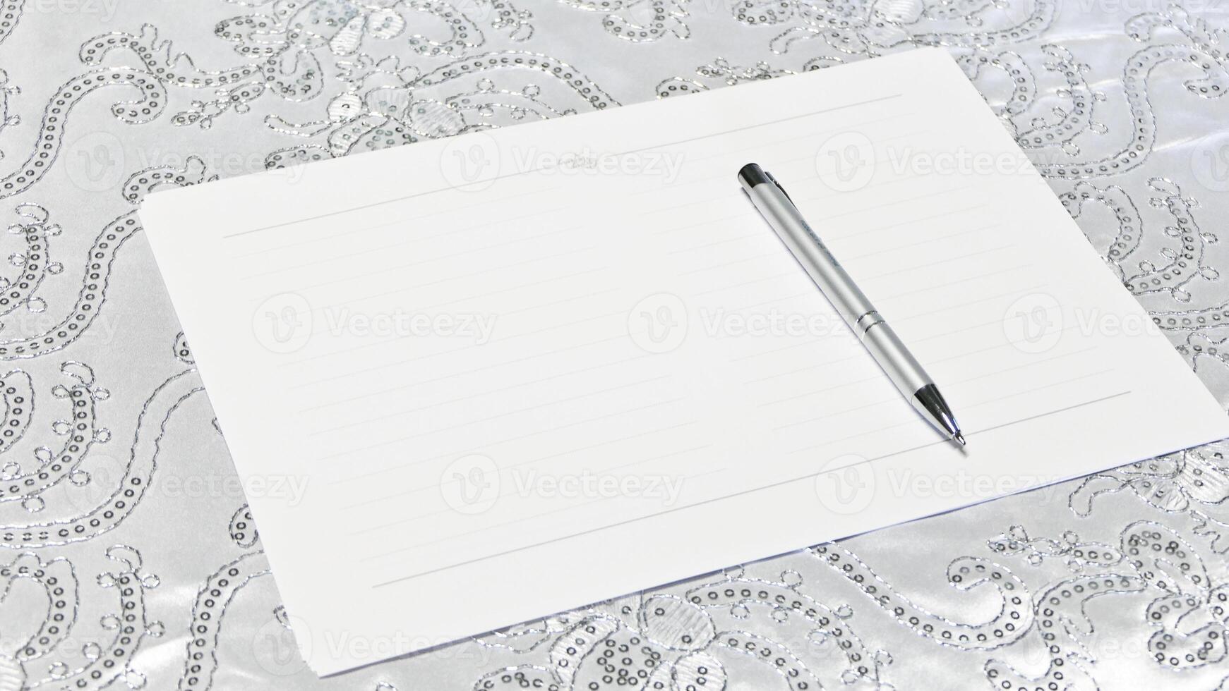 a pen and notepad on a silver table photo