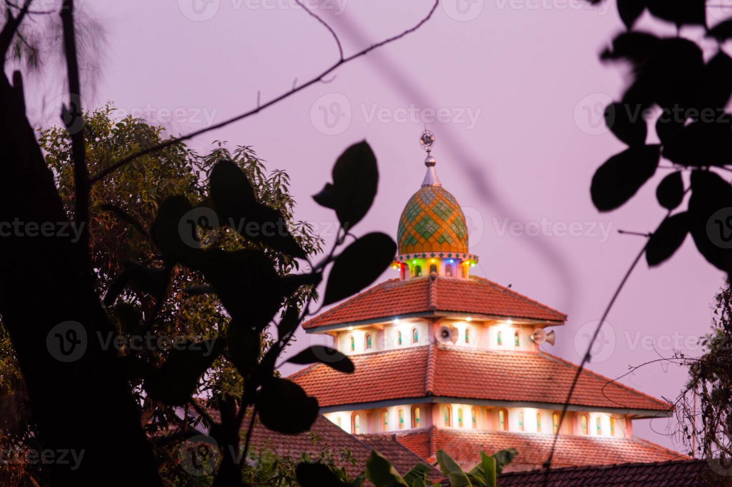 the mosque before sunset with the lights on photo
