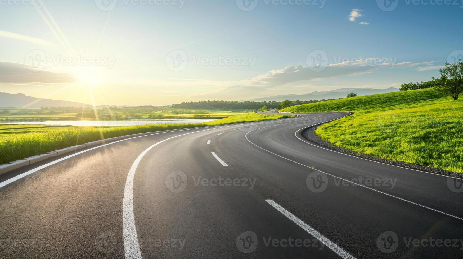An empty road with a sun shining in the background photo