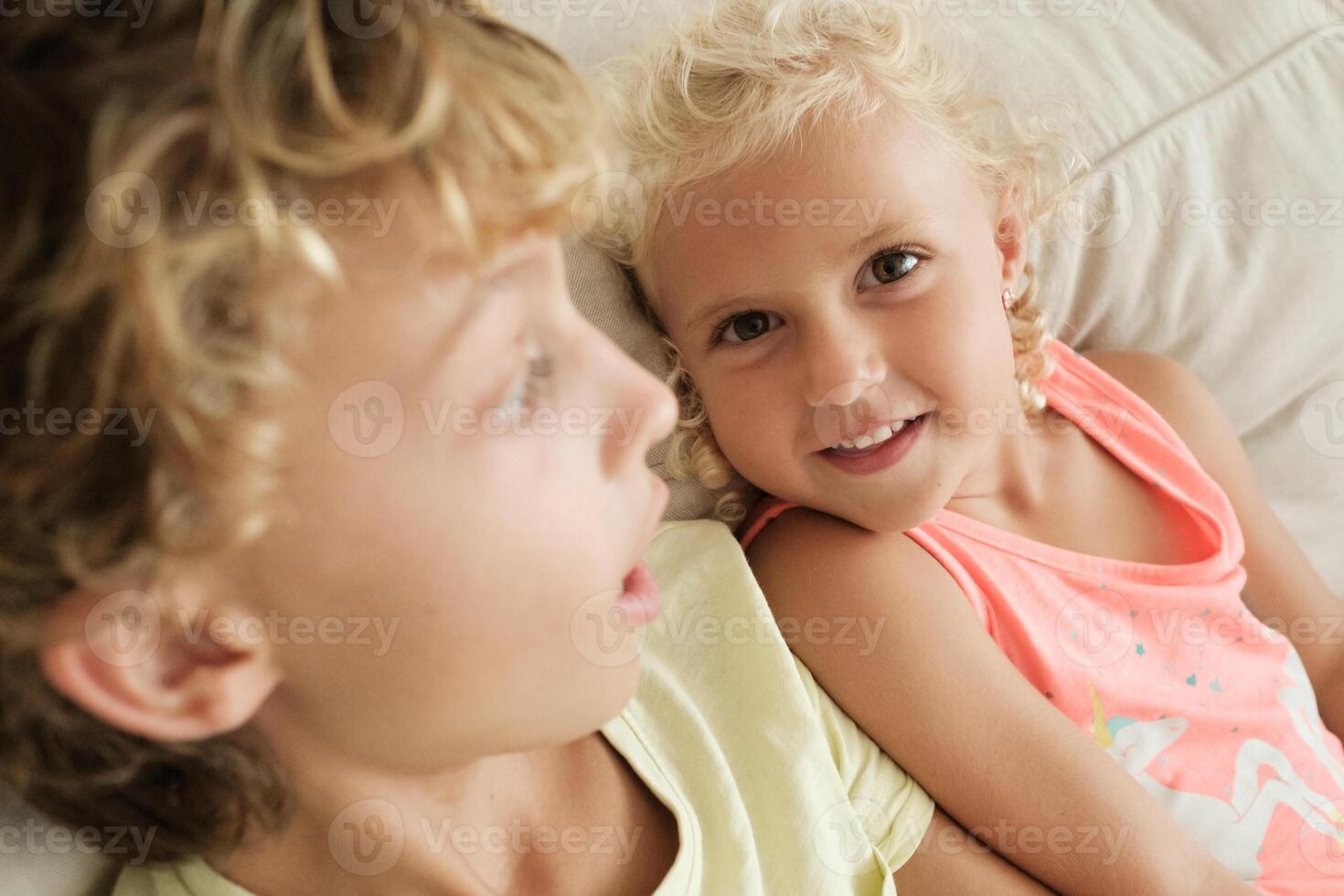 Content girl with sibling on sofa photo