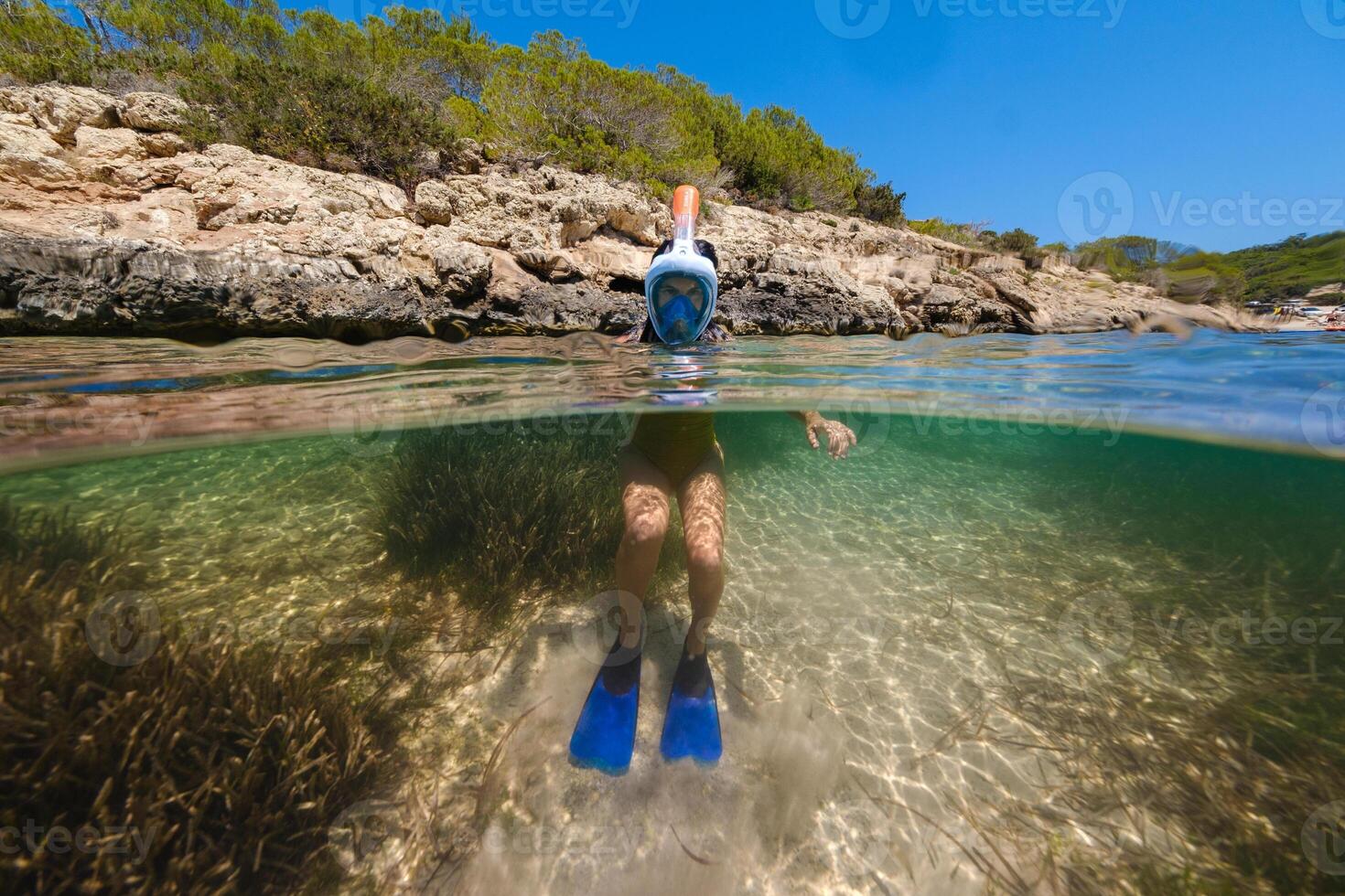 Anonymous boy in snorkeling mask in ocean photo