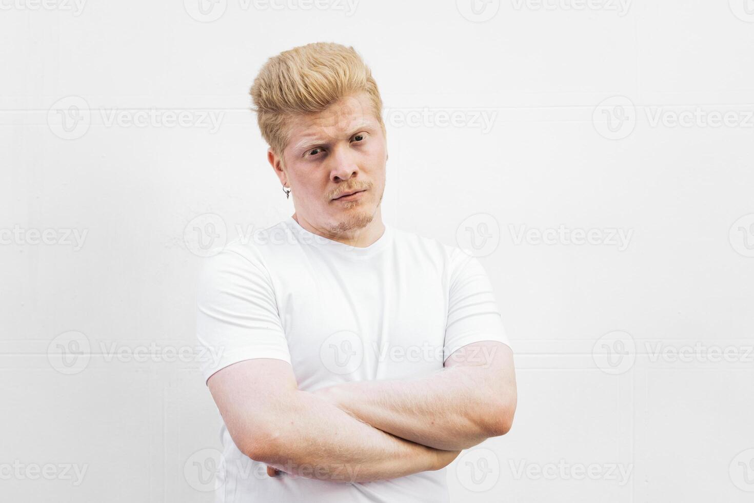 Portrait of an albino Latino man in white clothing with arm crossed photo