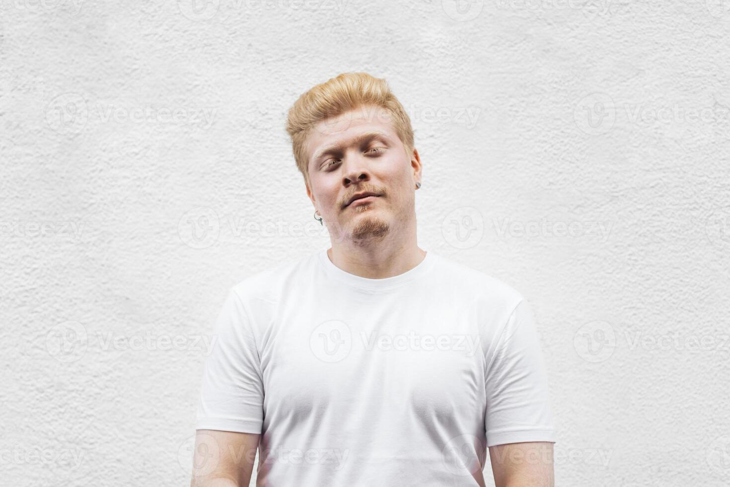 Portrait of an albino Latino adult man in white clothing against a white background. photo