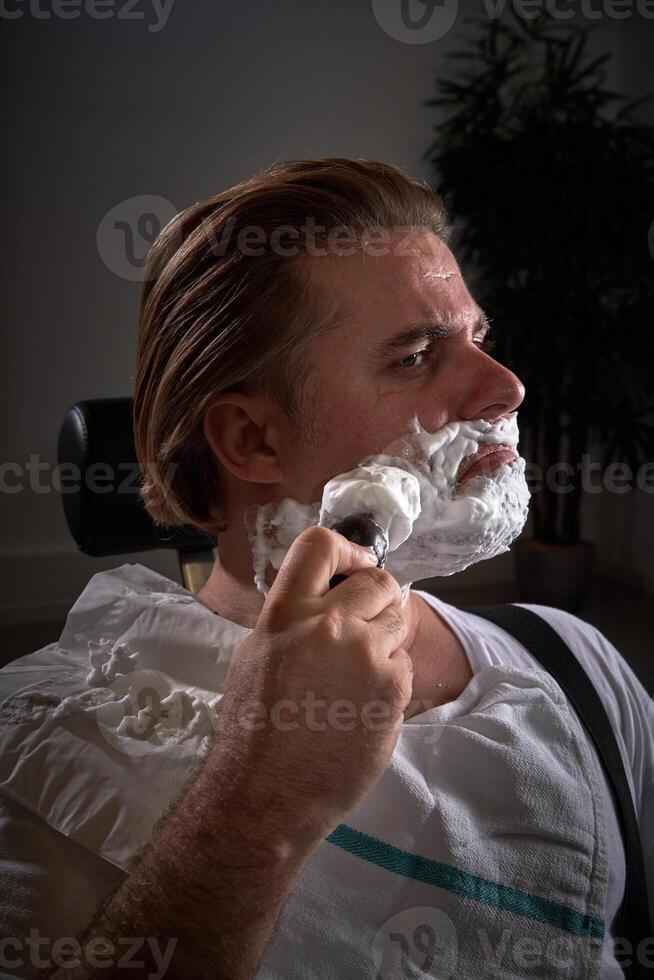 Man applying shaving foam in barbershop photo