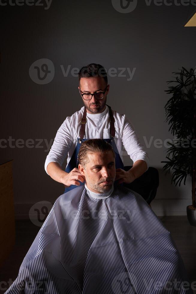 Barber making haircut to man photo