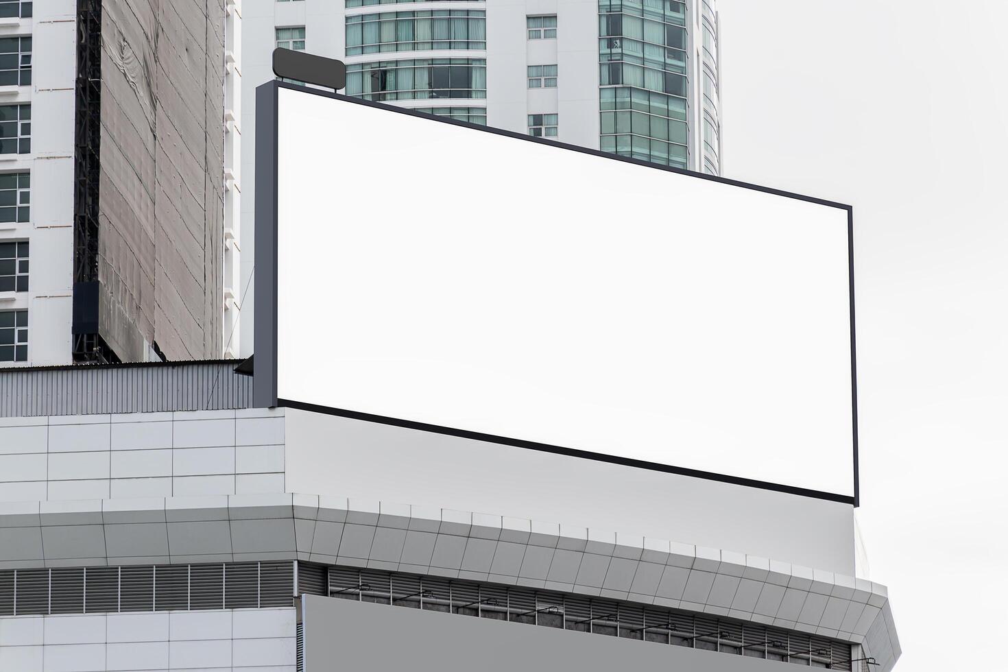 Mock up white horizontal large LED display billboard on rooftop building. clipping path for mockup photo
