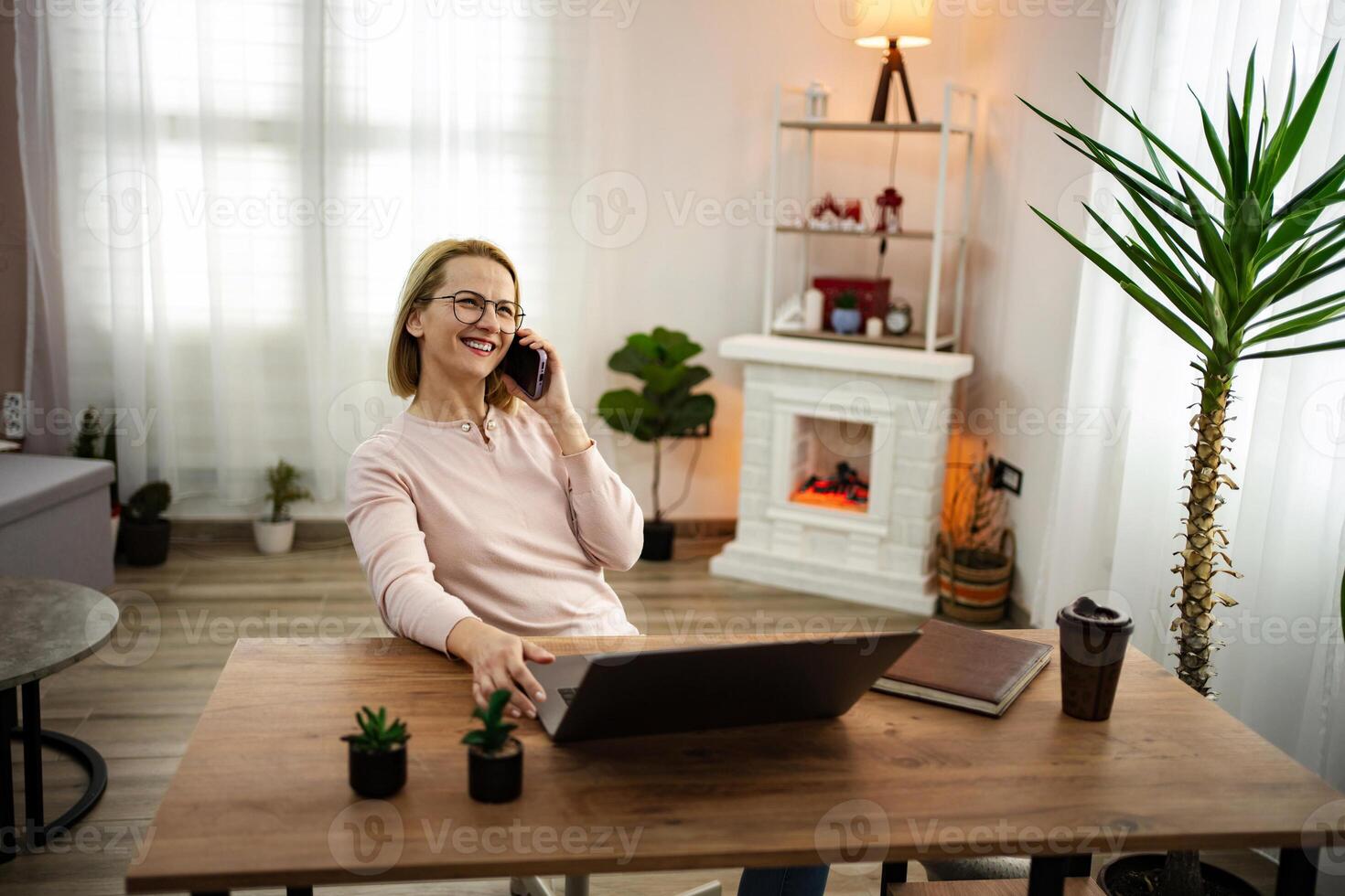 Enjoying a cozy moment at home while having a cheerful conversation on the phone during a sunny afternoon photo