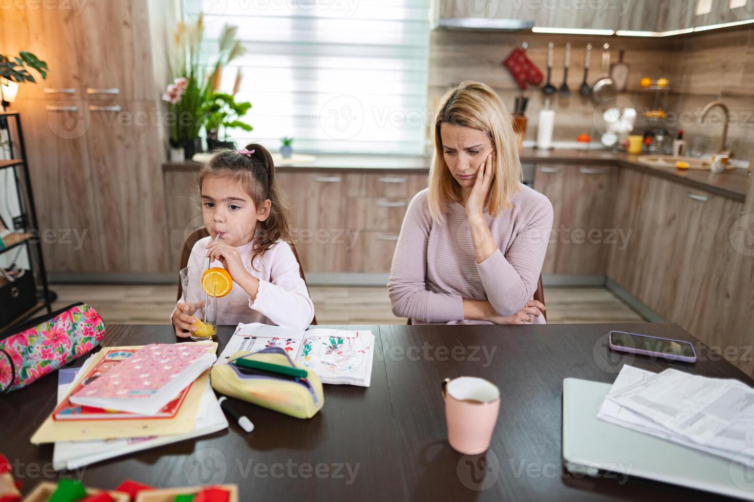 Child enjoying juice while mother reflects on challenges at home photo