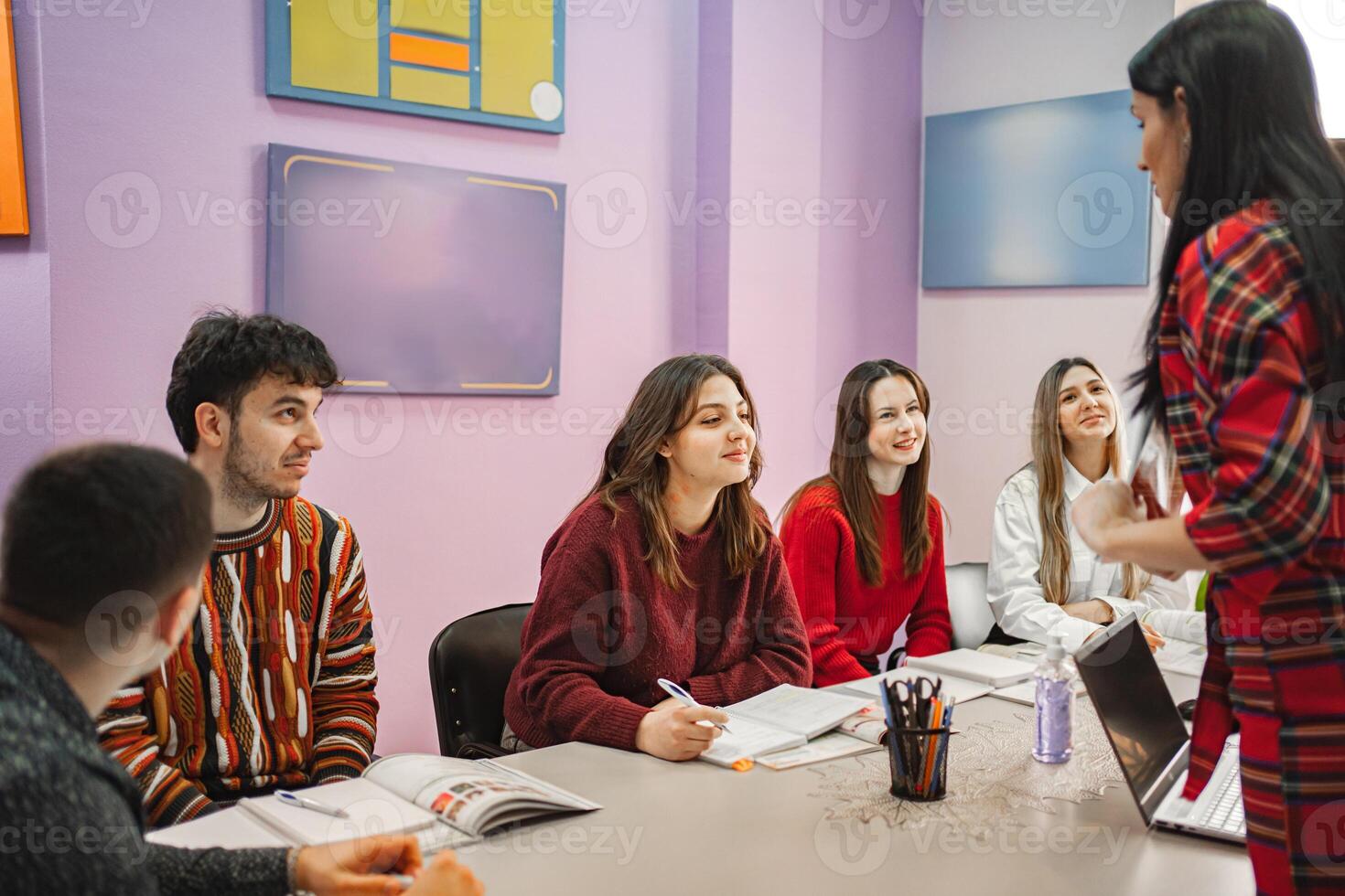 Female teacher explaining subject to her teenage students at language school photo